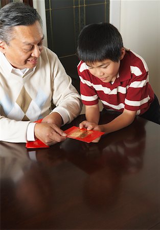 Grandfather and Grandson Holding Ang Pow Envelopes Stock Photo - Premium Royalty-Free, Code: 600-01073120