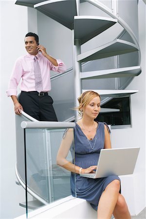 spiral staircase people - Couple at Staircase Using Cellular Phone and Laptop Stock Photo - Premium Royalty-Free, Code: 600-01073303