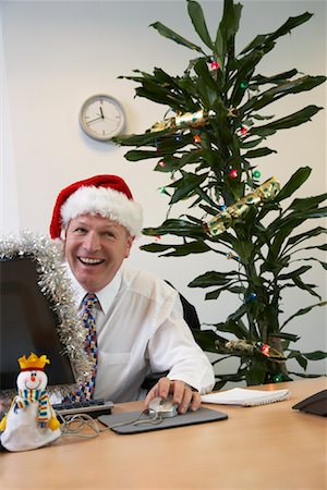 desk decorated for christmas - Businessman in Office with Christmas Decorations Stock Photo - Premium Royalty-Free, Code: 600-01083288