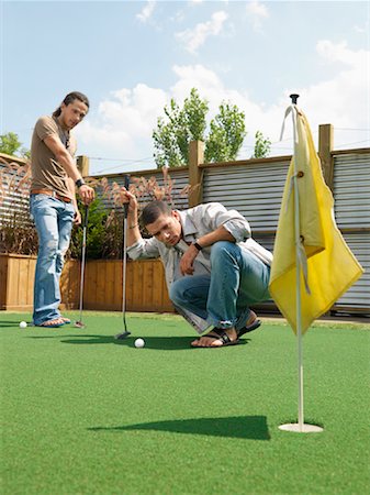 Friends Playing Miniature Golf Stock Photo - Premium Royalty-Free, Code: 600-01083745