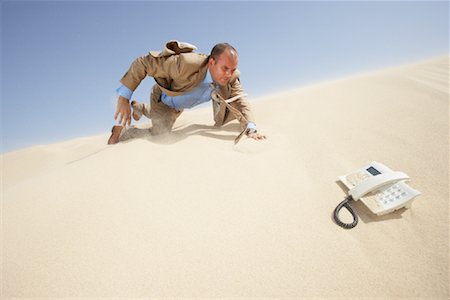 simsearch:700-00643992,k - Businessman Crawling Towards Telephone in Desert Fotografie stock - Premium Royalty-Free, Codice: 600-01109993