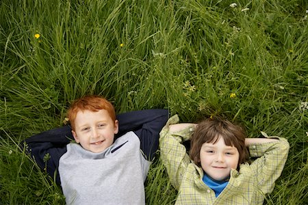 relaxed young caucasian boy hands behind head - Portrait of Boys Lying Down in Field of Grass Stock Photo - Premium Royalty-Free, Code: 600-01100018