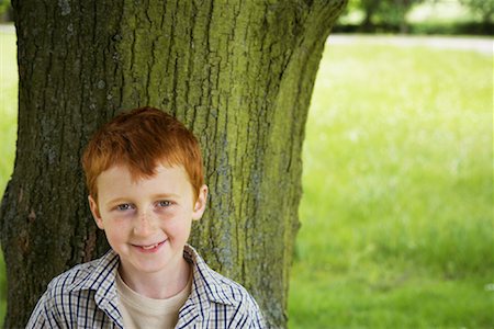 Portrait of Boy Standing in Front of Tree Stock Photo - Premium Royalty-Free, Code: 600-01100040