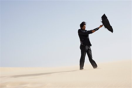 simsearch:693-06379198,k - Businessman in Desert with Windswept Umbrella Stock Photo - Premium Royalty-Free, Code: 600-01110014