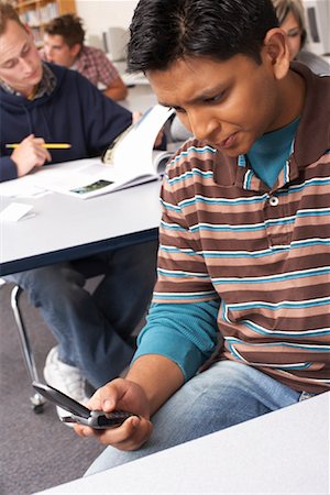 Student Using Cell Phone in Classroom Stock Photo - Premium Royalty-Free, Code: 600-01112266