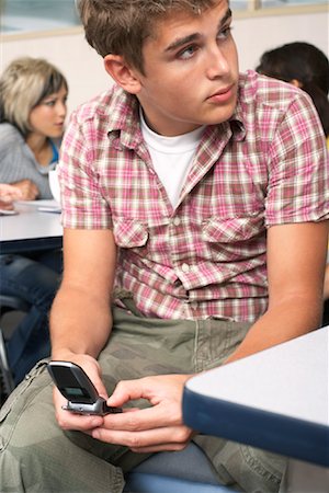 simsearch:640-02776597,k - Étudiant à l'aide de téléphone portable dans la salle de classe Photographie de stock - Premium Libres de Droits, Code: 600-01112267