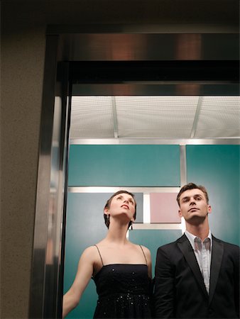 photo poses for suited dress - Portrait of Couple in Elevator Stock Photo - Premium Royalty-Free, Code: 600-01124208