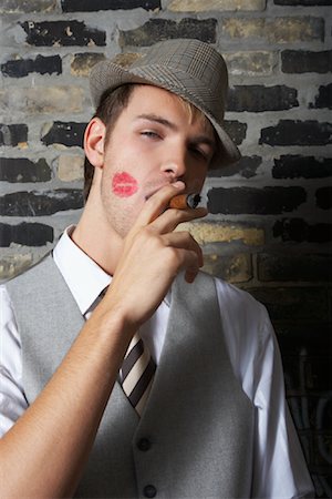 Portrait of Man With Lipstick Mark on Cheek, Smoking a Cigar Stock Photo - Premium Royalty-Free, Code: 600-01163447