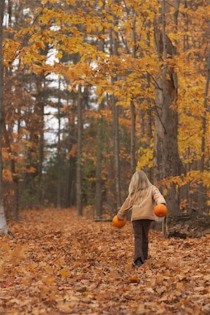 Girl Walking Through Autumn Leaves Stock Photo - Premium Royalty-Free, Code: 600-01163992