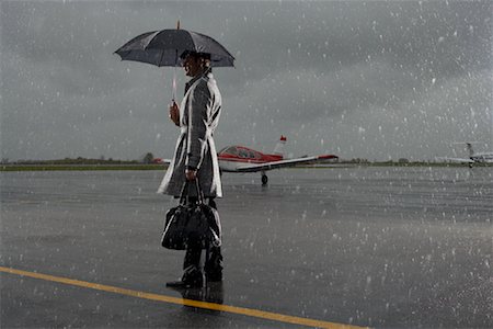 Homme debout sur le Tarmac par temps de pluie Photographie de stock - Premium Libres de Droits, Code: 600-01174005