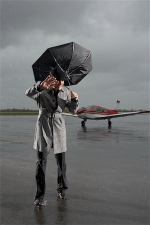 Homme pris dans une tempête sur le Tarmac de l'aéroport Photographie de stock - Premium Libres de Droits, Code: 600-01174008