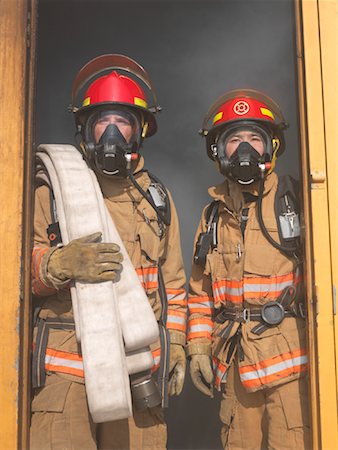 simsearch:400-06392786,k - Firefighters Carrying Hose out of Smoky Building Fotografie stock - Premium Royalty-Free, Codice: 600-01172199