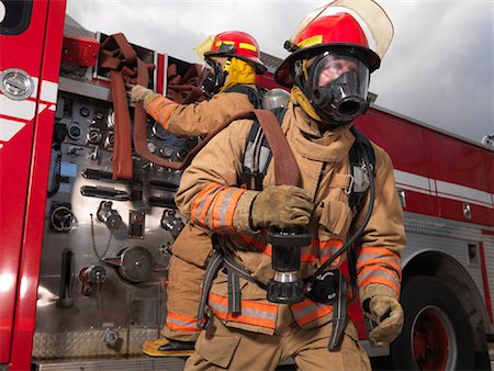 Firefighters Pulling Fire Hose from Fire Truck Fotografie stock - Premium Royalty-Free, Codice: 600-01172248