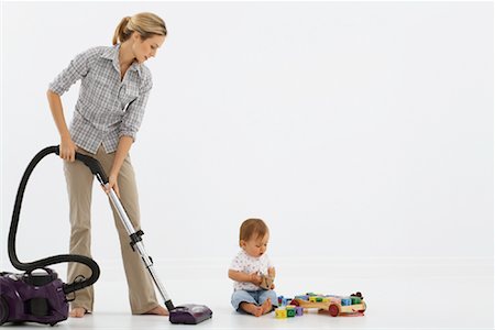 Woman Vacuuming, Baby Playing with Toys Stock Photo - Premium Royalty-Free, Code: 600-01172797