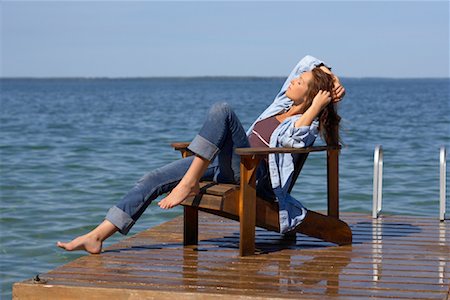 sitting on a chair beautiful blond woman - Woman Relaxing on Dock by Water Stock Photo - Premium Royalty-Free, Code: 600-01172978