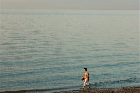 Man Walking on Beach Stock Photo - Premium Royalty-Free, Code: 600-01173581