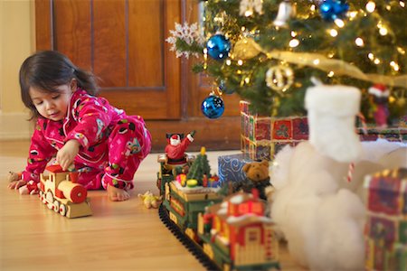 Girl Playing with Toy Train on Christmas Morning Stock Photo - Premium Royalty-Free, Code: 600-01195002