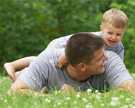 father son lying grass - Father and Son Outdoors Foto de stock - Sin royalties Premium, Código: 600-01195562