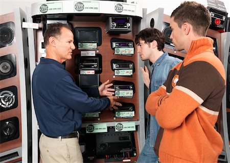 sales associate talking with customer - Two Men Listening to Salesperson in Electronics Store Stock Photo - Premium Royalty-Free, Code: 600-01198758