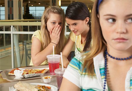 Two Teens Whispering Behind Another Girl's Back Stock Photo - Premium Royalty-Free, Code: 600-01275534