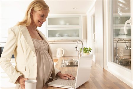 Pregnant Woman Using Laptop in Kitchen Foto de stock - Sin royalties Premium, Código: 600-01296109