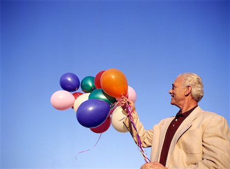 Man Holding Bunch of Balloons Stock Photo - Premium Royalty-Free, Code: 600-01296390