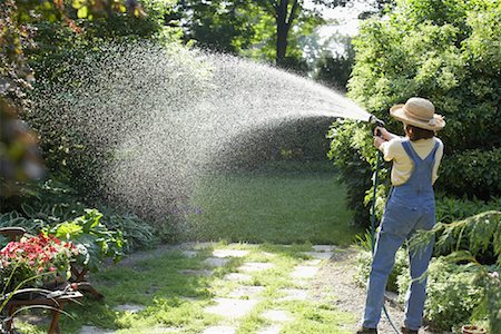 Woman Watering Garden Foto de stock - Sin royalties Premium, Código: 600-01374783