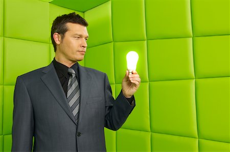 percée (découverte) - Homme avec ampoule électrique dans la salle capitonnée vert Photographie de stock - Premium Libres de Droits, Code: 600-01407178