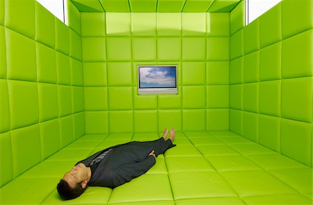 simsearch:695-03380266,k - Mann liegt auf Rücken in grün gepolsterten Raum mit Telelvision Stockbilder - Premium RF Lizenzfrei, Bildnummer: 600-01407172