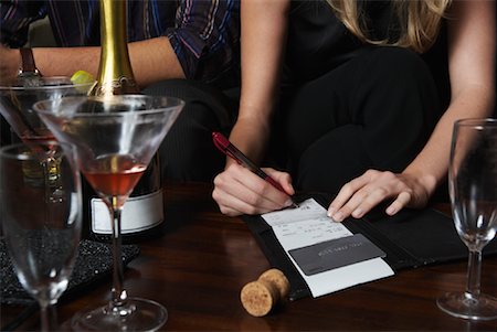 Woman Signing Bill at Bar Stock Photo - Premium Royalty-Free, Code: 600-01459240