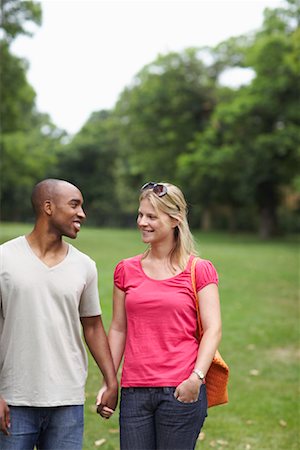 picture of white and black people holding hands - Couple Walking in Park Stock Photo - Premium Royalty-Free, Code: 600-01540661