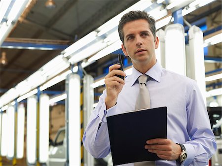 person on phone with clipboard - Man in Automotive Plant Stock Photo - Premium Royalty-Free, Code: 600-01575561