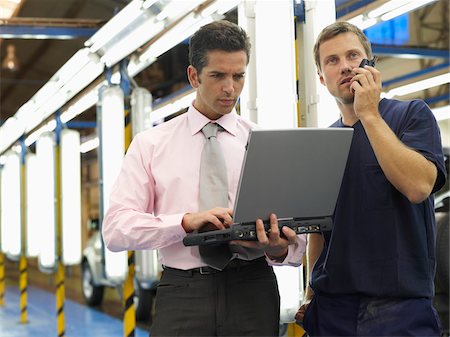 person looking at phone and car - Men in Automotive Plant Stock Photo - Premium Royalty-Free, Code: 600-01575562
