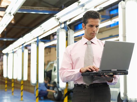 equipamiento pesado - Man Using Laptop in Automotive Plant Foto de stock - Sin royalties Premium, Código: 600-01575563