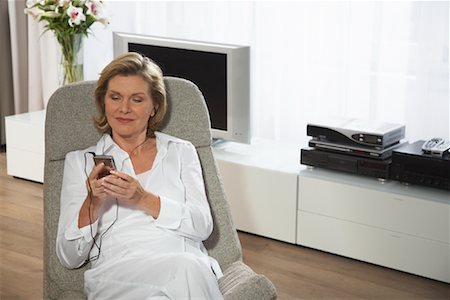 photo of people sit listening to radio - Woman Using MP3 Player Stock Photo - Premium Royalty-Free, Code: 600-01575656