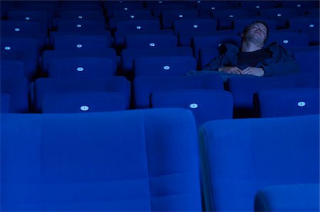 people in the movie theater line - Man Sleeping in Movie Theatre Stock Photo - Premium Royalty-Free, Code: 600-01572000