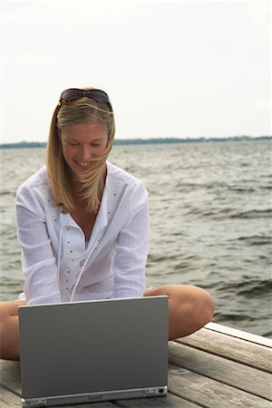 Woman Using Laptop Computer on Dock Stock Photo - Premium Royalty-Free, Code: 600-01585684