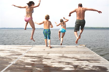 people jumping into water back view - Family Jumping from Dock Foto de stock - Sin royalties Premium, Código: 600-01585889