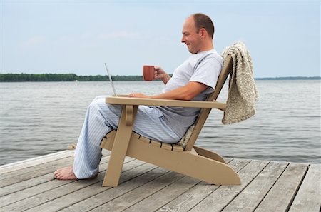 person sitting in adirondack chair - Man Relaxing on Dock Stock Photo - Premium Royalty-Free, Code: 600-01585899