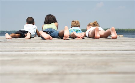 preteen boy soles - Children Lying on Dock Stock Photo - Premium Royalty-Free, Code: 600-01585919