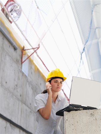 female worker on phone - Engineer Talking on Cell Phone, Using Laptop Computer Stock Photo - Premium Royalty-Free, Code: 600-01593899