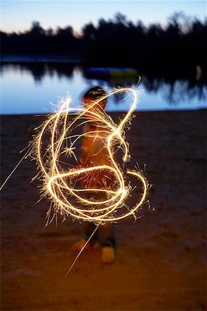 Child Playing with Sparkler by Lake Stock Photo - Premium Royalty-Free, Code: 600-01606214