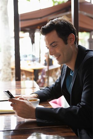 Man Using Cellphone in Cafe Stock Photo - Premium Royalty-Free, Code: 600-01606507