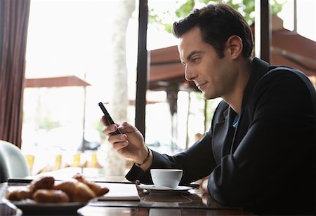 Man Using Cellphone in Cafe Stock Photo - Premium Royalty-Free, Code: 600-01606509