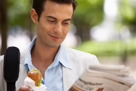 Man Eating Sandwich and Reading Newspaper Stock Photo - Premium Royalty-Free, Code: 600-01606541