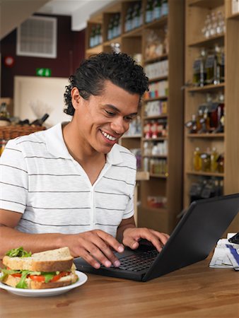 picture of man sitting alone diner - Man Using Laptop in Deli Stock Photo - Premium Royalty-Free, Code: 600-01606705