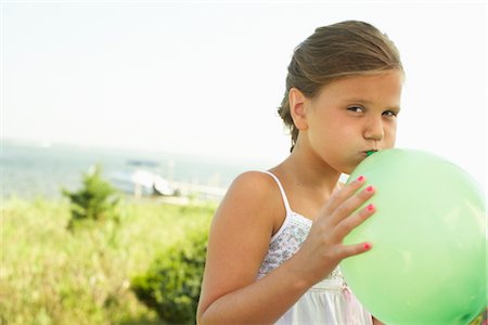 Girl Blowing Up Balloon Stock Photo - Premium Royalty-Free, Code: 600-01614153