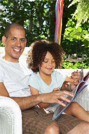 dad reads to children the book in the chair - Father Reading Book with Daughter Stock Photo - Premium Royalty-Free, Code: 600-01614268