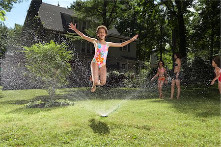 people outside home cold - Family playing in backyard with sprinkler Stock Photo - Premium Royalty-Free, Code: 600-01614309