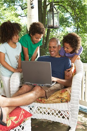 Portrait of Father with Laptop Surrounded by Children Stock Photo - Premium Royalty-Free, Code: 600-01614301